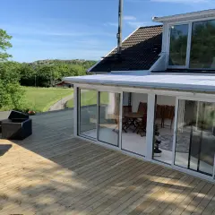 Ny slipad altan med glasveranda och utemöbler. Perfekt för att njuta av sommaren.