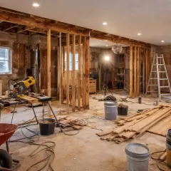 Byggarbetsplats för att renovera hus. Verktyg, byggmaterial och en stege syns i rummet.