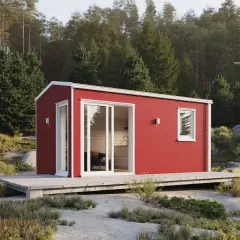 Röd friggebod med stora fönster och altan, placerad i en skogsglänta. Perfekt för dig som vill flytta friggebod och skapa en egen oas.