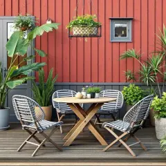 Vacker uteplats med ett runt träbord, randiga stolar och massor av gröna växter i krukor utomhus inspiration.