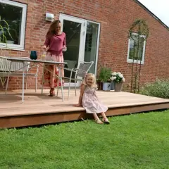 En kvinna och ett barn njuter av en sommardag på en vacker syllpapp altan.