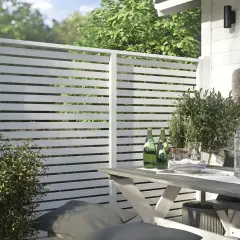Modern vitt staket ger stilig staket inspiration. En uteplats med bord, stolar och grönska.