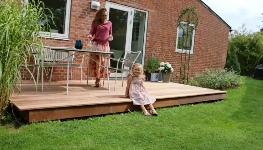 En kvinna och ett barn njuter av en sommardag på en vacker syllpapp altan.