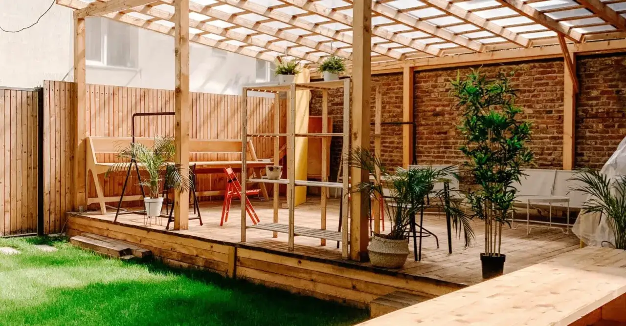 En mysig uteplats med tr&auml;pergola, b&auml;nkar och v&auml;xter. Tr&auml;et &auml;r behandlat f&ouml;r att t&aring;la v&auml;der och vind, perfekt f&ouml;r att m&aring;la tryckimpregnerat.