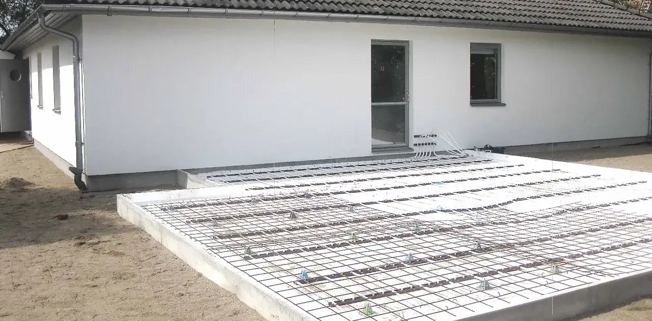 Förberedelser för gjuta betongplatta med golvvärmeslingor. Armeringsnät och isolering på plats.
