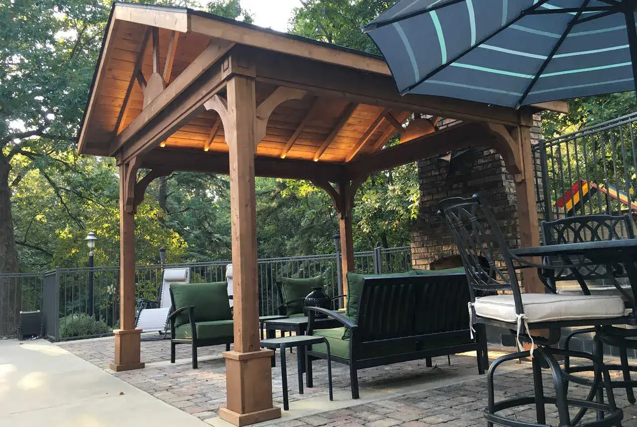 Välkomnande vasstak pergola med bekväma sittplatser och utomhuseldstad. Perfekt för avkoppling i trädgården.