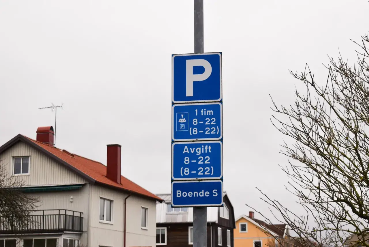 Parkeringsskylt i villaområde visar regler: 1 timme, avgift och boendeparkering.