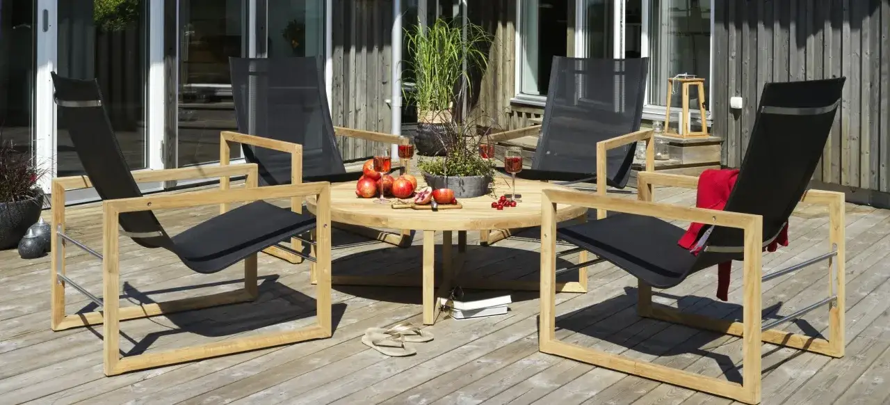 En inredd altan utan tak med bekv&auml;ma stolar och ett runt bord dukat med frukt och dryck. Perfekt f&ouml;r avkoppling.