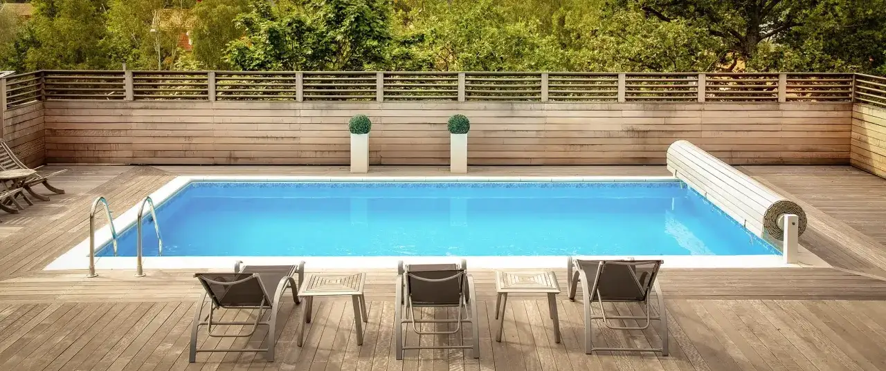 En vacker pool med tr&auml;d&auml;ck och solstolar. Dr&ouml;mmen om att gjuta egen pool blir verklighet h&auml;r.